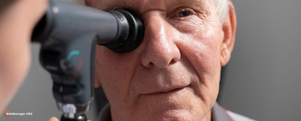 תמונת תקריב על פניו של אדם מבוגר עם שיער לבן, עובר בדיקת ראייה ותוך כדי שומע מהרופא מה אסור לעשות אחרי ניתוח קטרקט. בצד שמאל למטה לוגו אתר blog.webmanager.