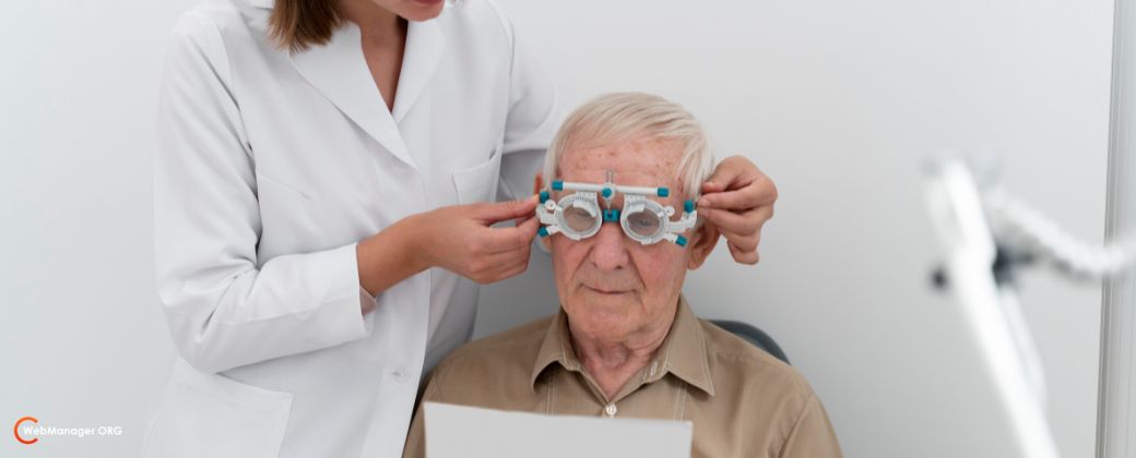 רואים קצוות שיער של אשת צוות רפואי אשר מסבירה למטופל מה אסור לעשות אחרי ניתוח קטרקט תוך כדי שהיא שמה על פניו מתקן כלשהו לבדיקת ראייה. בצד שמאל למטה לוגו אתר blog.webmanageR