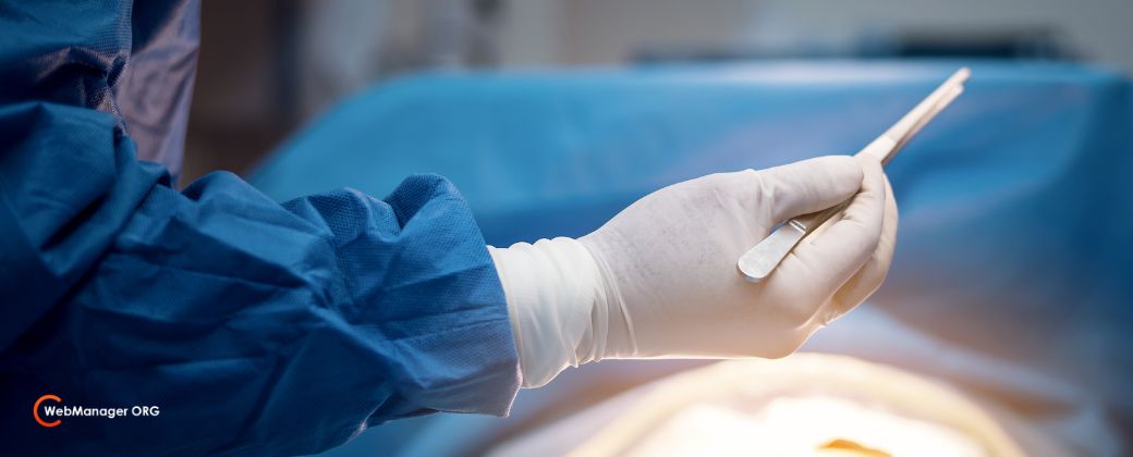 נקודת חן סרטנית - ניתן לראות ידיים של רופא כירורג בפעולה על גבי מנותח ובצד למטה לוגו אתר blog.webmanager